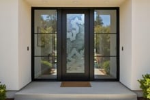 Modern black front door with glass featuring a custom sandblast Streams design, a high-quality durable and handcrafted modern entry that highlights a bold black exterior finish with sidelights.