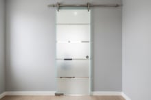 Modern glass barn door installed in a small living space, showing how sliding glass saves floor area