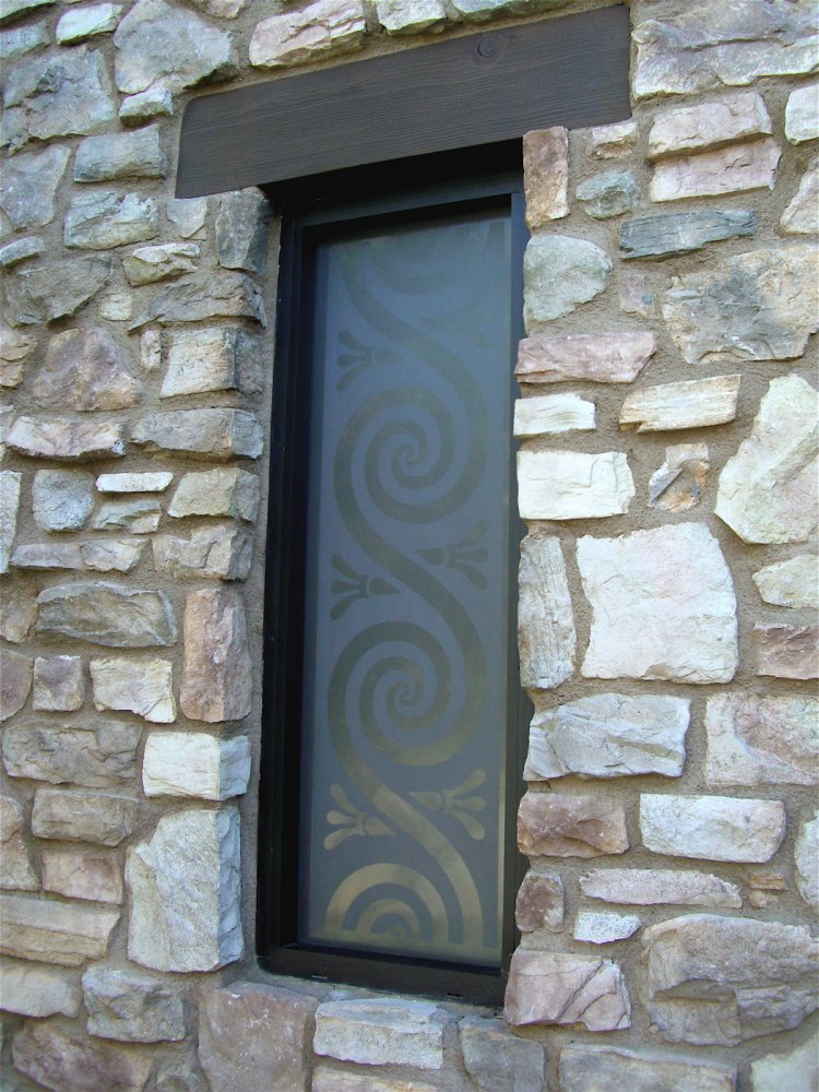 A really fun and even perhaps "whimsical" design, this window features swirls and shapes that are lightly frosted, with the background etched solid.