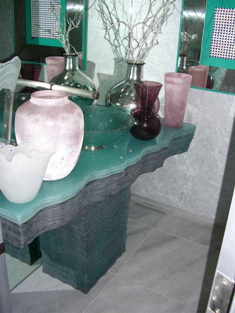 This elaborate glass vanity features multiple layers of hand chiseled edge glass, each layer being 3/4" thick, layered one on top of the other.  The top is finished off with a back painted glass layer.  Not shown in these photos, are the fact that this vanity is also LIT and completely glows.
