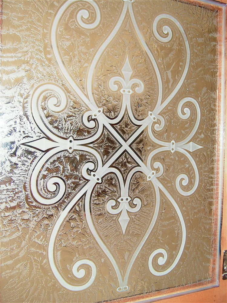 Cabinet Glass - Sans Soucie Art Glass  A close up view of the carved wrought iron motif, kitchen cabinet glass  with a