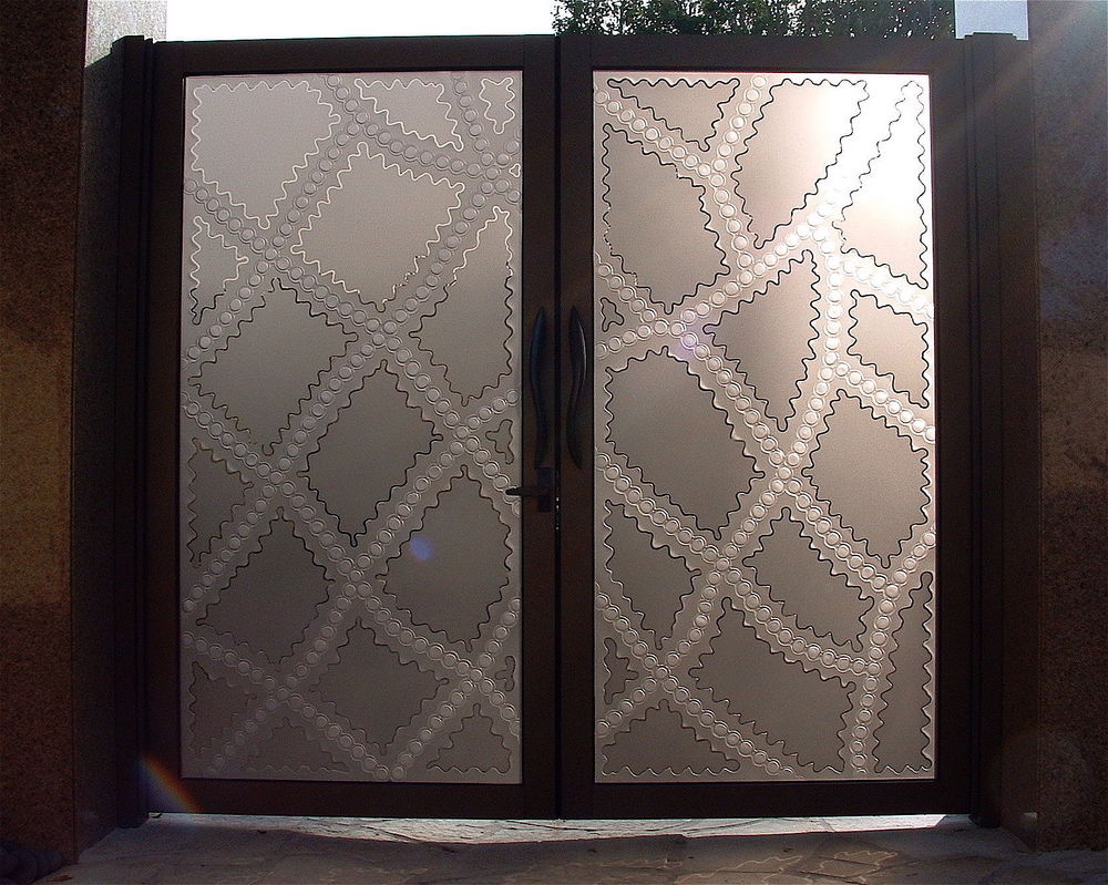 Custom etched glass gate featuring geometric diamond artwork and decorative frosted glass inserts for residential entryways.