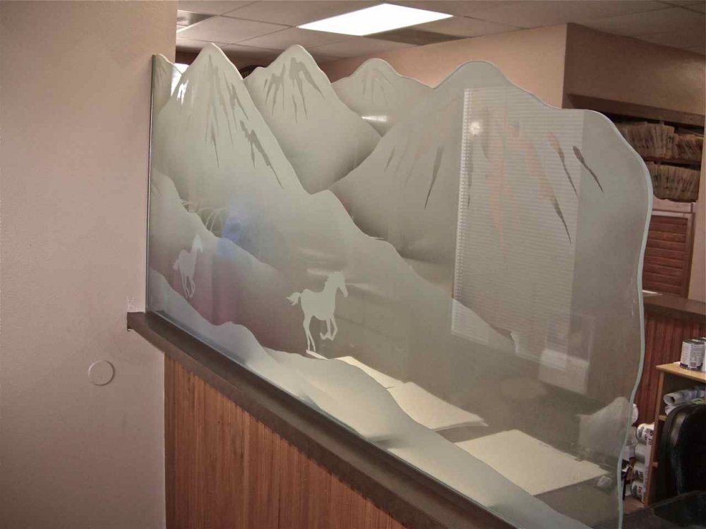 Custom etched glass panel with running horses and mountain scenery installed as interior pony wall divider