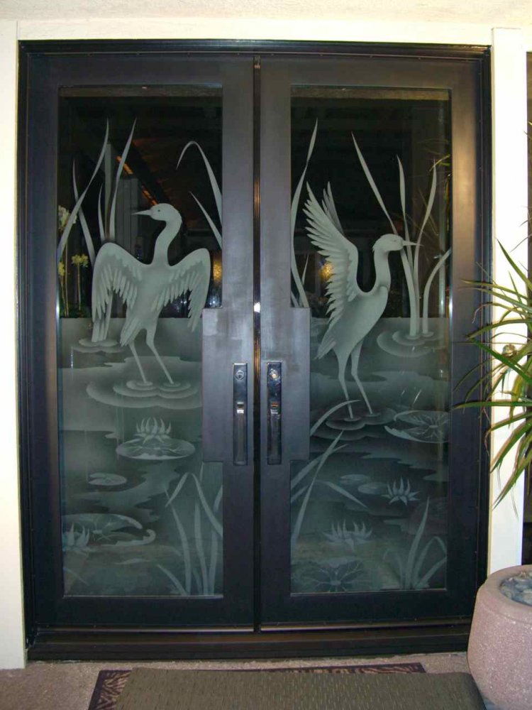 Black framed front doors with detailed frosted glass crane design providing semi-privacy with layered sandblasted effects and artistic depth