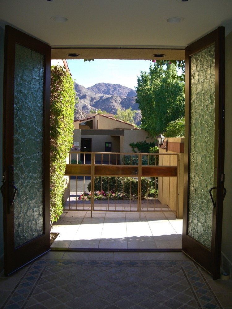 Open textured glass front doors with cast glass panels creating privacy while allowing a filtered view of the outdoor landscape