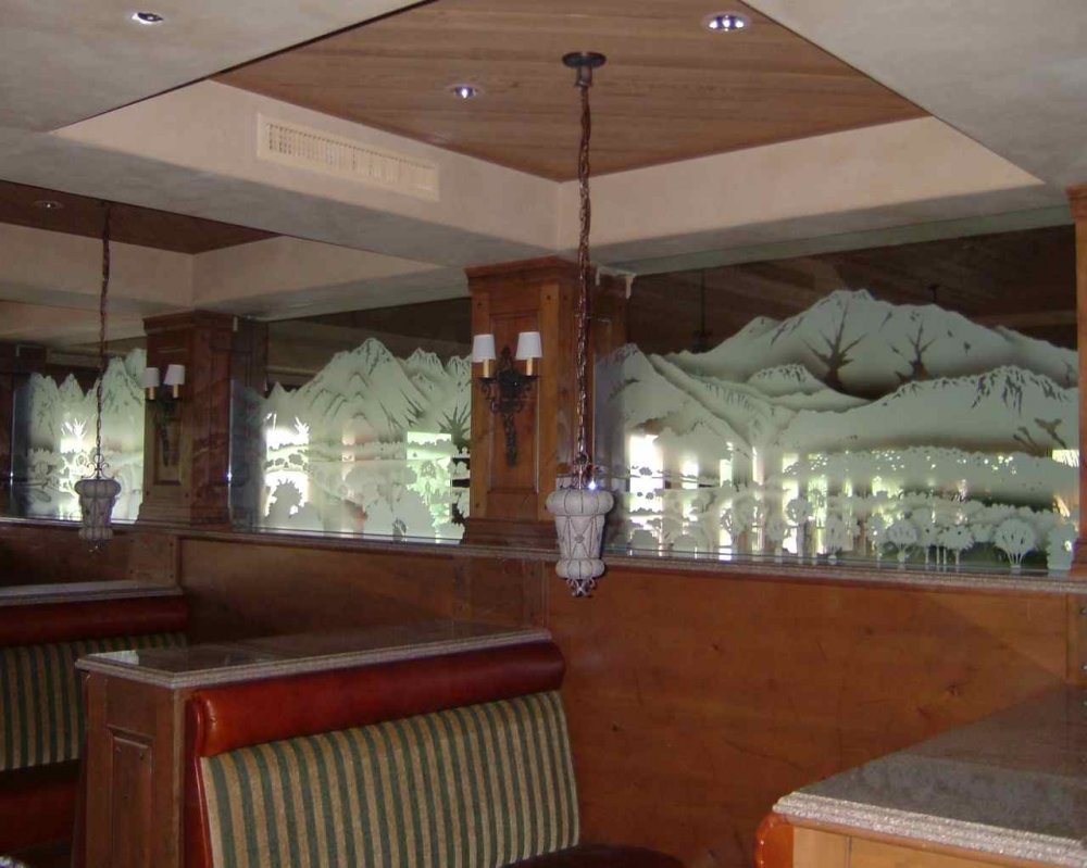 Large etched glass partition with detailed mountain landscape scene, custom frosted glass divider enhancing privacy in restaurant booth seating area