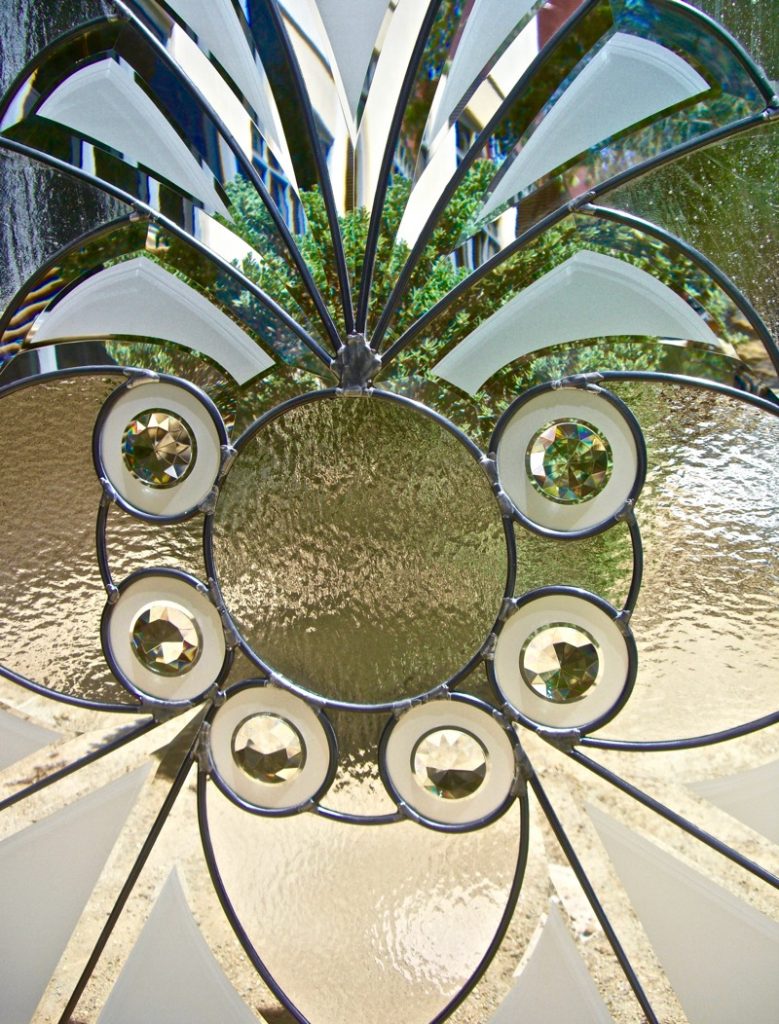 Close-up of intricate beveled glass reflecting light with prism-like sparkle.
