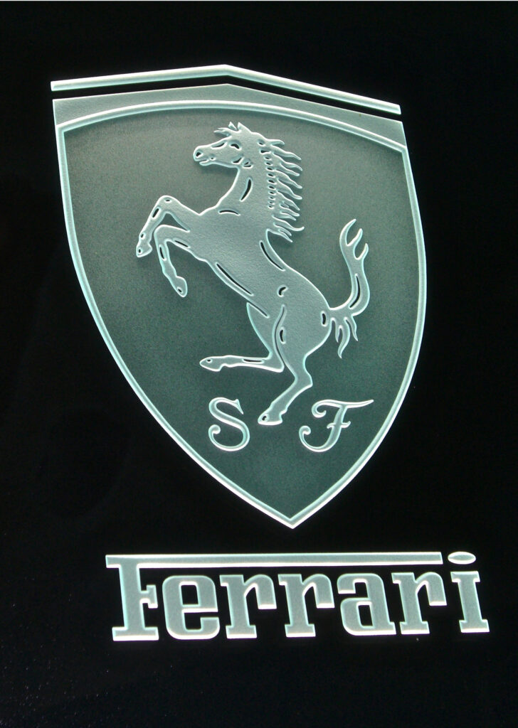 Custom carved glass sign featuring detailed logo design, demonstrating high-end branding with a sleek and polished aesthetic