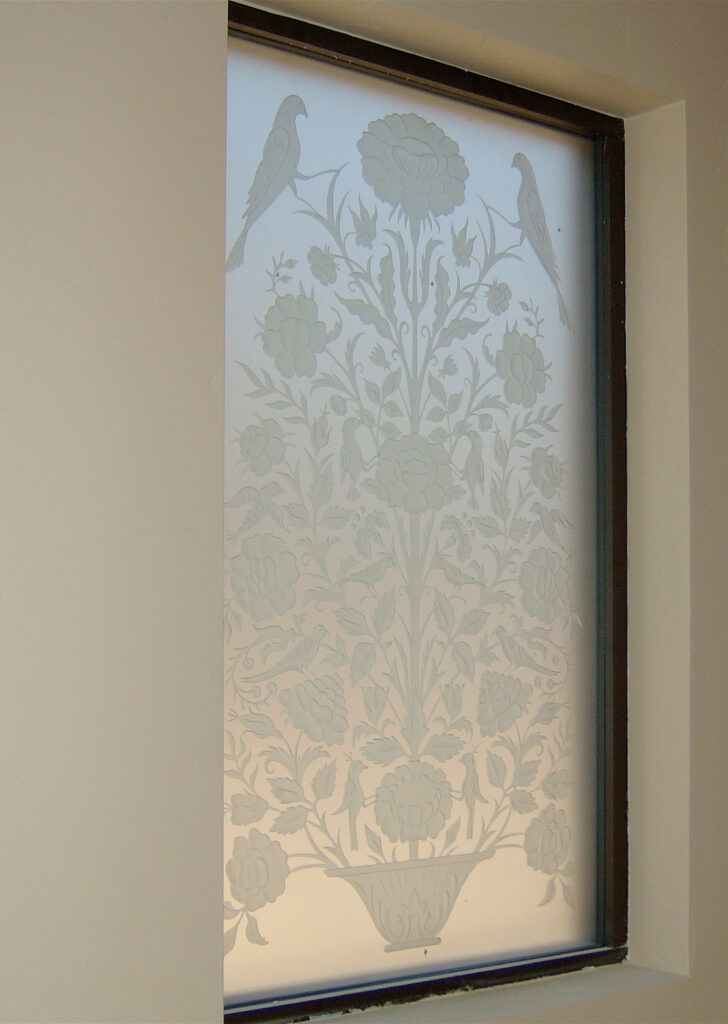 Etched glass stairwell window with floral and bird design adds privacy to transitional areas while softly diffusing natural light