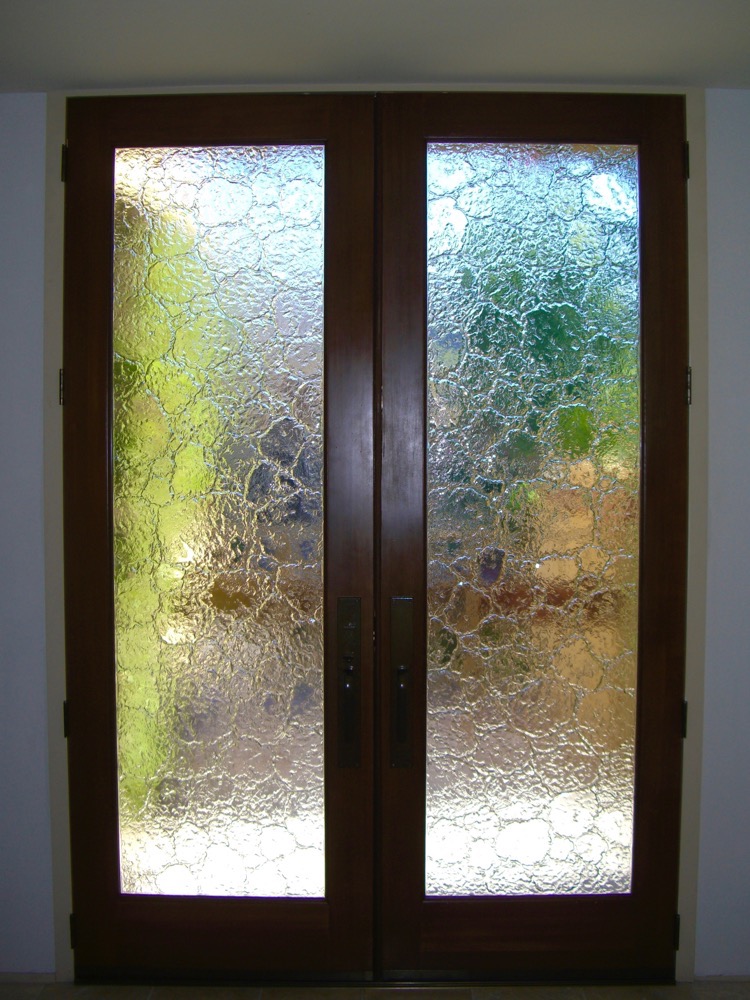 Textured glass front doors with heavy obscured pattern offering maximum privacy and soft light transmission in an entryway