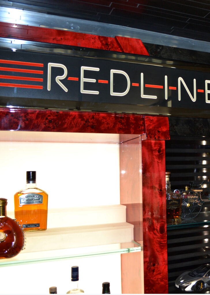 Illuminated glass sign with bold red and black background, showcasing high contrast for enhanced visibility in a modern commercial interior