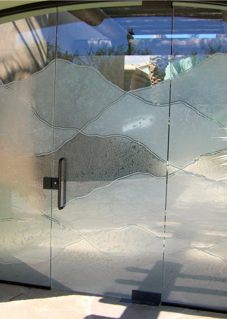 Etched glass gate with abstract hill design, showcasing a frameless frosted glass entry gate with layered carved textures and privacy glass.