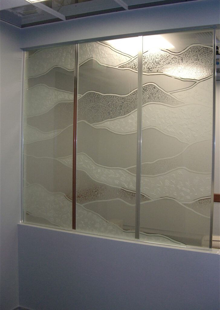Etched glass panel featuring abstract hills design