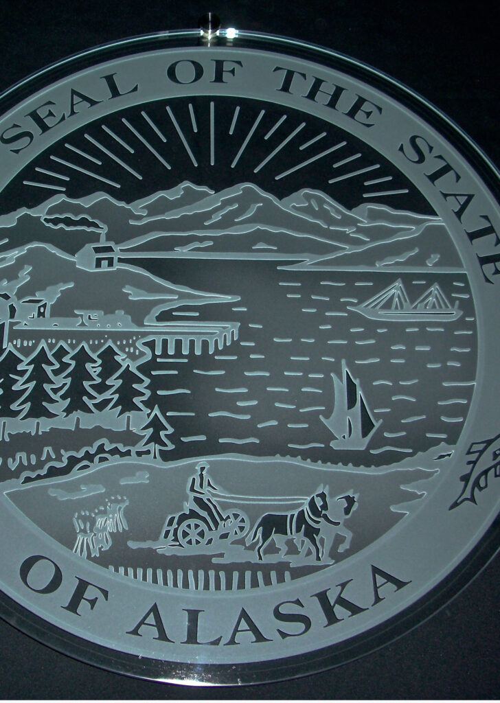 Custom carved glass sign featuring the Seal of the State of Alaska, showcasing detailed etched design suitable for government or institutional spaces