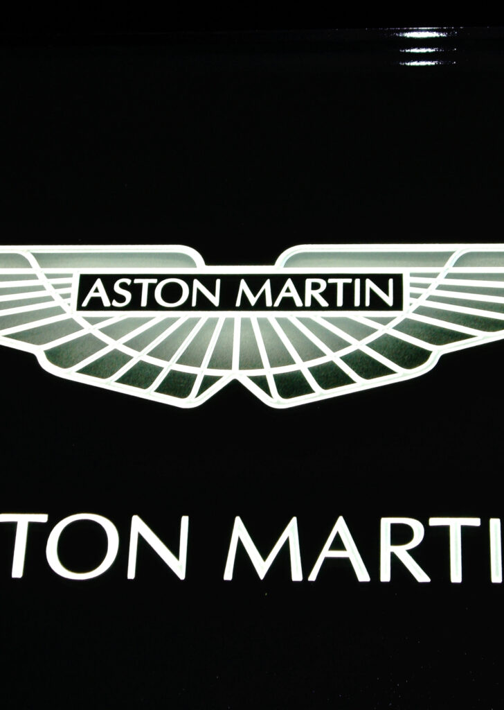 Decorative glass sign with Aston Martin logo, illuminated etched glass branding sign with sleek modern design