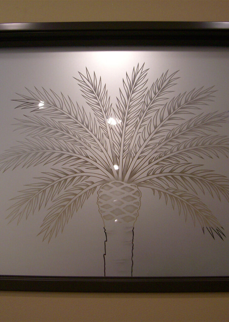 Etched glass interior panel featuring palm tree design, decorative frosted glass for office privacy and tropical-inspired branding