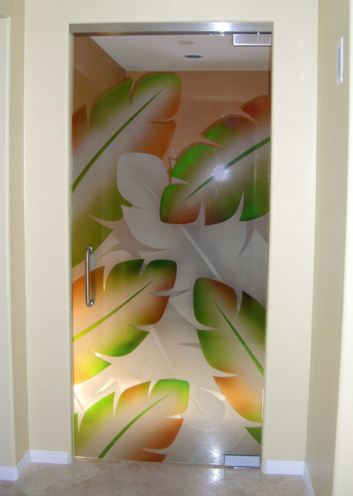 Custom frameless glass pantry door with deeply carved frosted glass artwork Banana Leaves, designed for a bright and stylish kitchen.