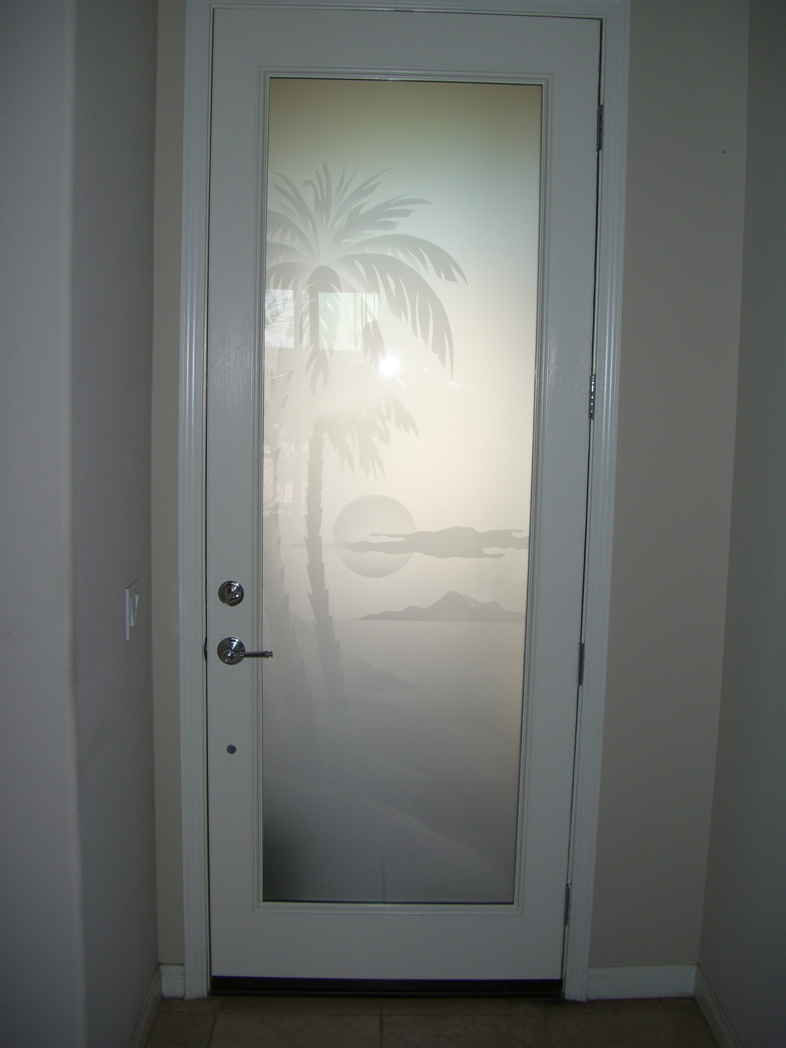 frosted glass front door with palm tree sunset etched design for tropical coastal home entry