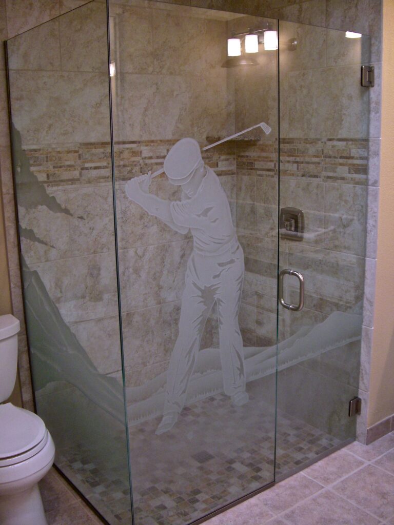 Glass shower enclosure with frosted glass golfer design sandblasted into tempered glass with desert landscape background