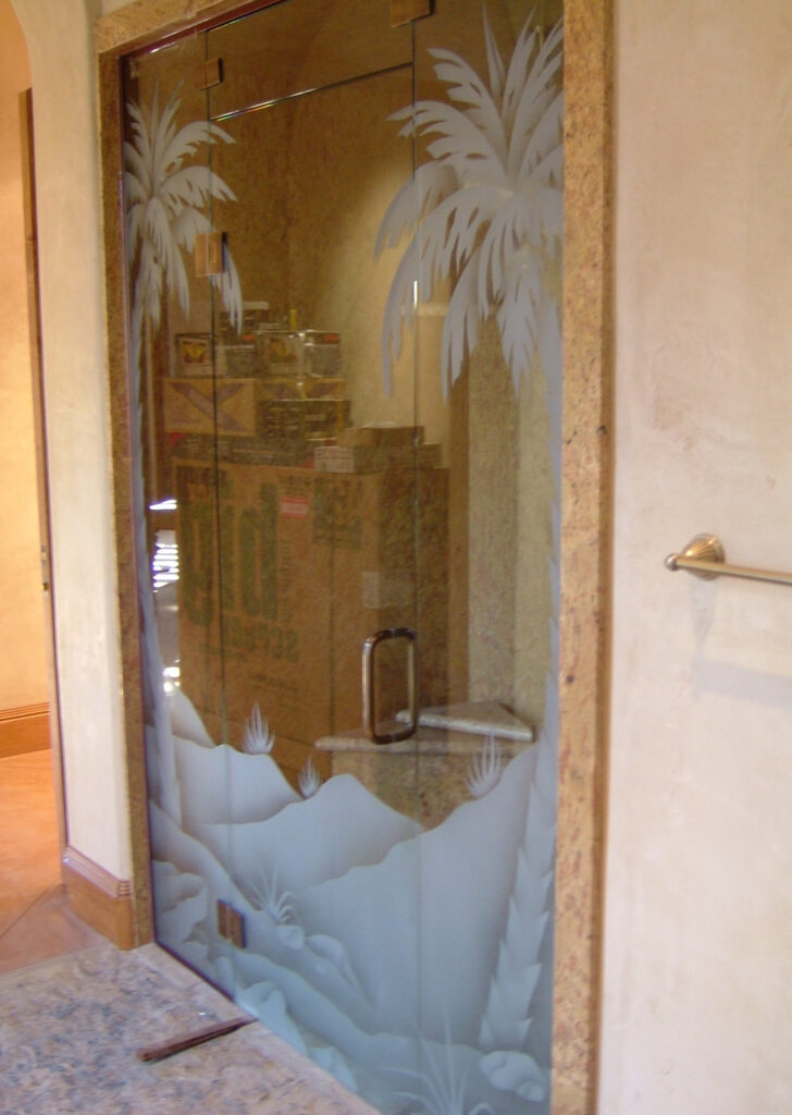 Frameless etched glass shower enclosure with dual palm tree design, custom sandblasted glass panels with desert landscape scene