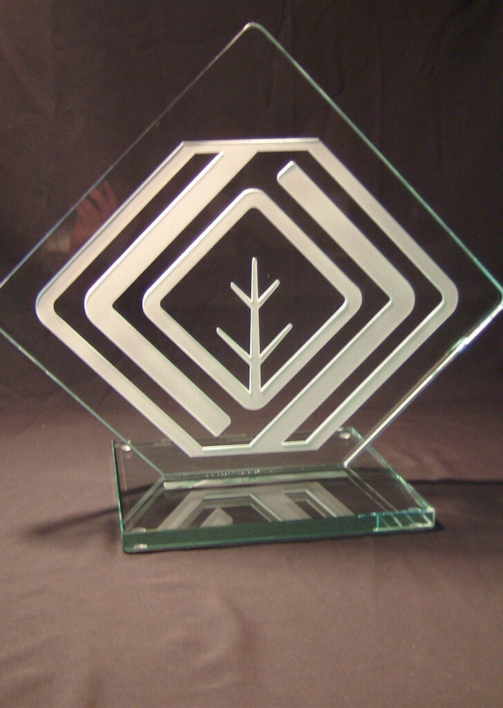 Custom carved and etched glass plaque with geometric logo design, mounted on base for a modern and sleek decorative display