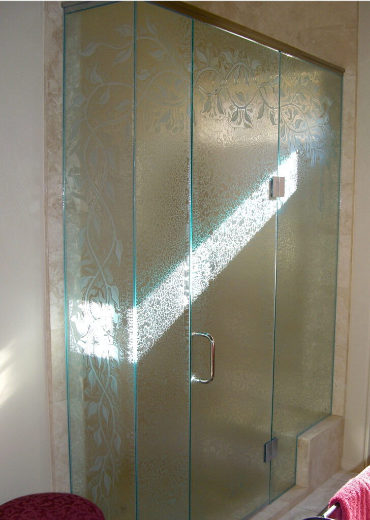 Custom frameless shower enclosure with frosted ivy vine design and textured privacy glass panels