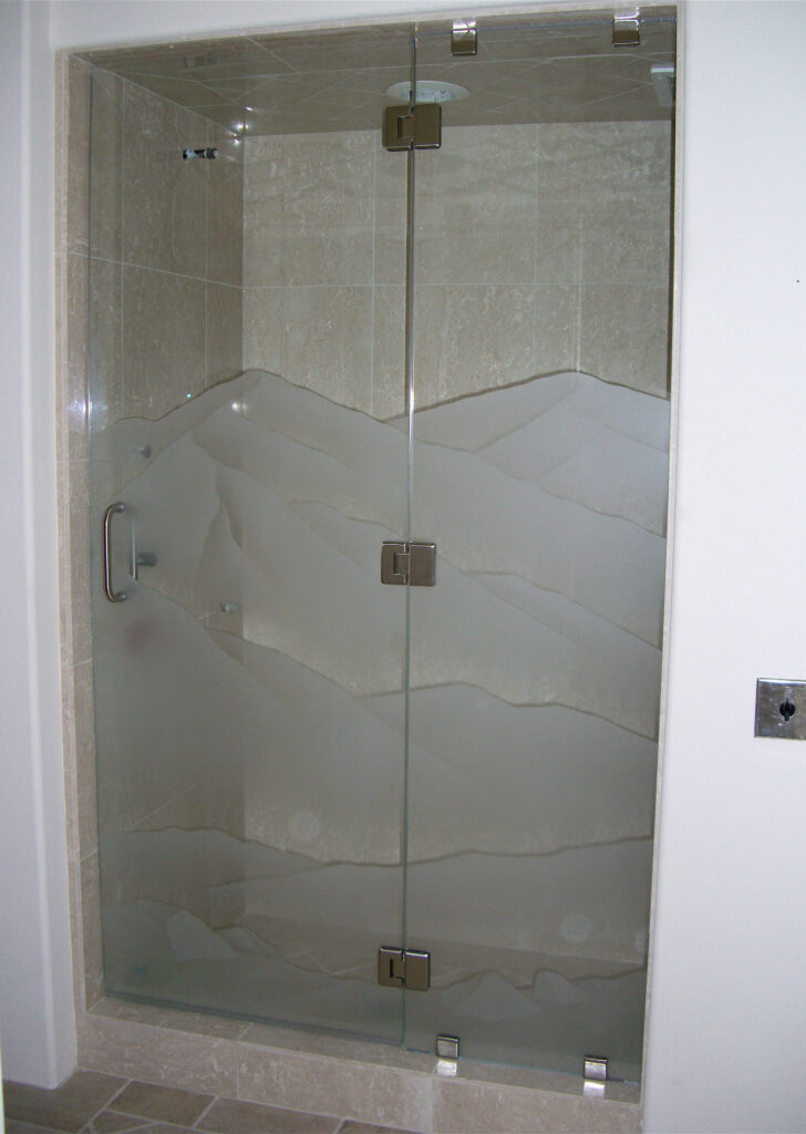 Frameless shower doors with frosted glass mountain landscape design sandblasted into tempered glass for privacy and natural light
