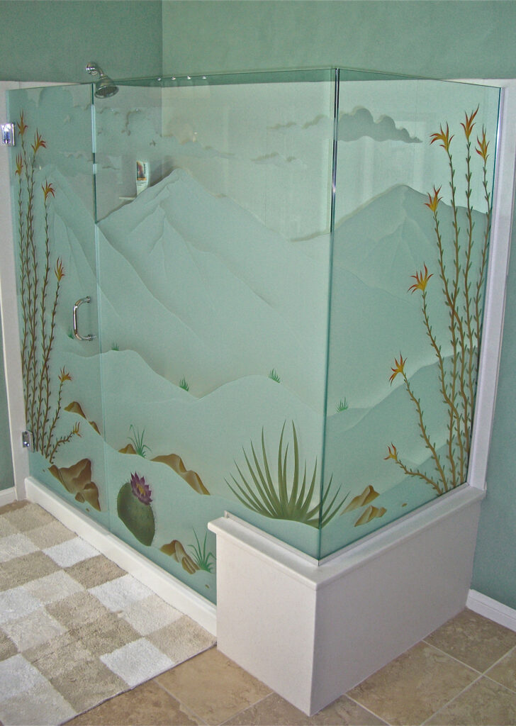 Corner shower enclosure with frosted and painted glass featuring a desert landscape design with mountains, cactus, and agave plants