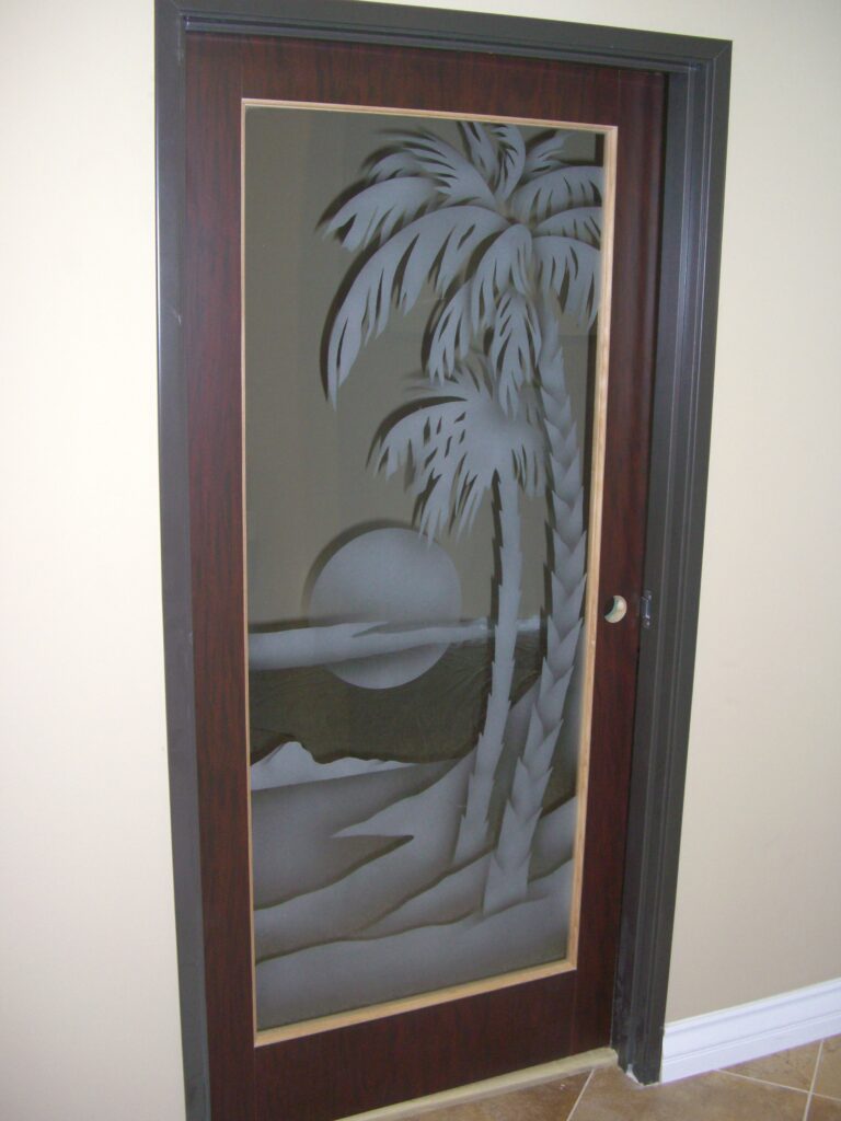 Etched glass door with palm tree and sunset beach scene