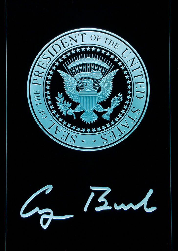 edge-lit carved glass panel featuring the Presidential Seal of the United States with illuminated etched details and signature