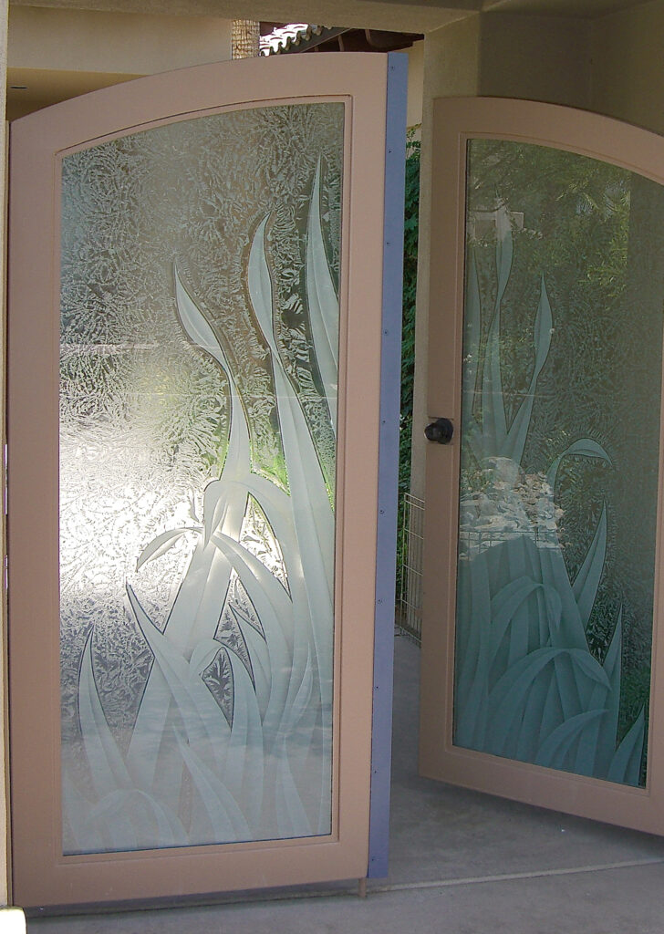 Decorative entry gate glass insert with etched reed artwork and textured frosted background, adding privacy and natural beauty to a custom glass gate.