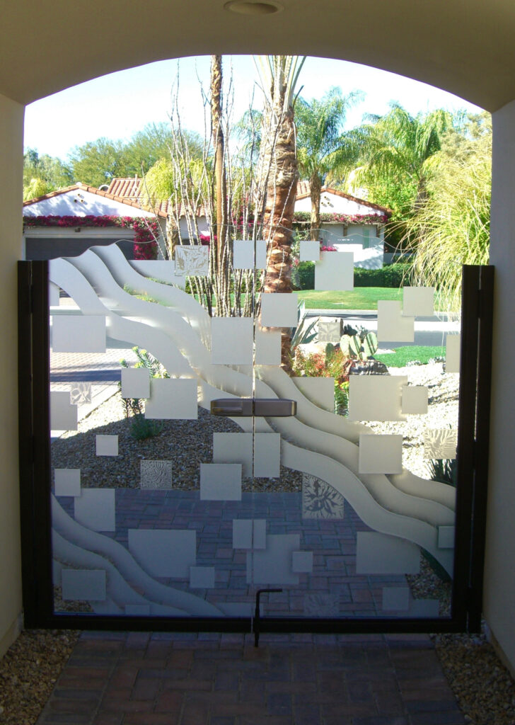 Decorative entry gate glass insert with floating squares and wave-inspired etched glass design for modern residential entrances.