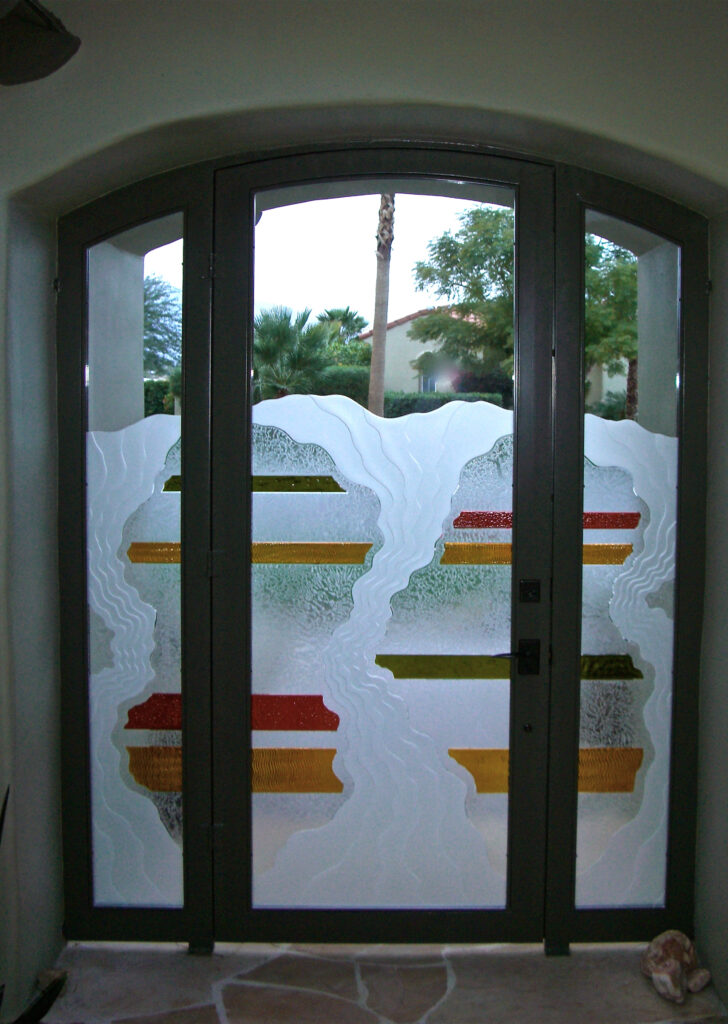 Custom glass entry gate with abstract frosted and colored glass artwork, adding privacy and artistic style to a courtyard entrance.