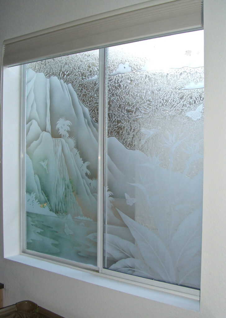 Etched glass kitchen window with tropical waterfall scene offers privacy at the sink while still letting in soft natural light