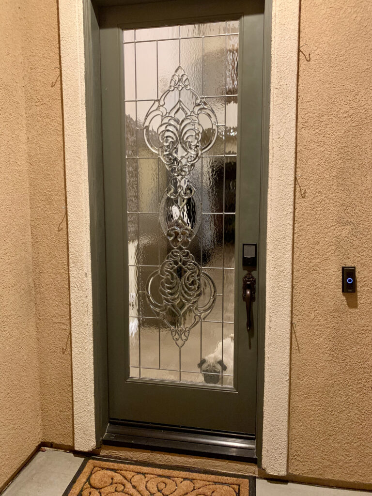 Ornate beveled glass door with a pug peeking through the glass