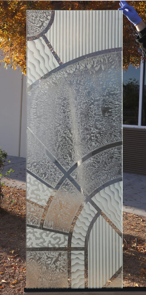 Modern glass door panel with abstract arcs, carved textures, and frosted privacy, showing custom glass door options for contemporary homes.