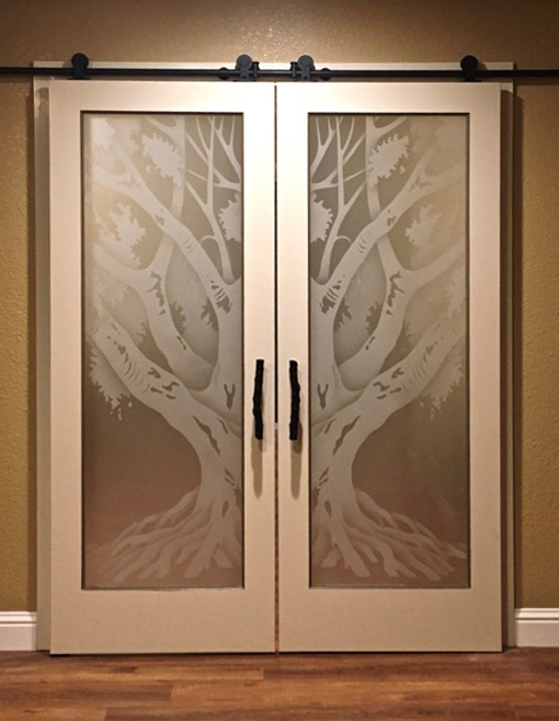 Frosted glass barn doors with tree design in soft ambient lighting showing light diffusion and subtle contrast