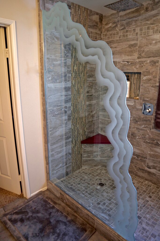Glass wall partition decorative shower divider featuring flowing shoreline wave patterns in etched glass