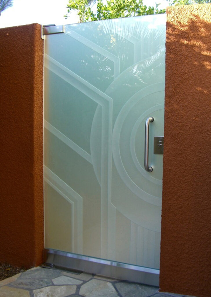 Acid-etched glass gate with sandblasted geometric designs, illustrating how a smooth frosted finish can be enhanced with carved patterns to create depth, visual interest, and privacy