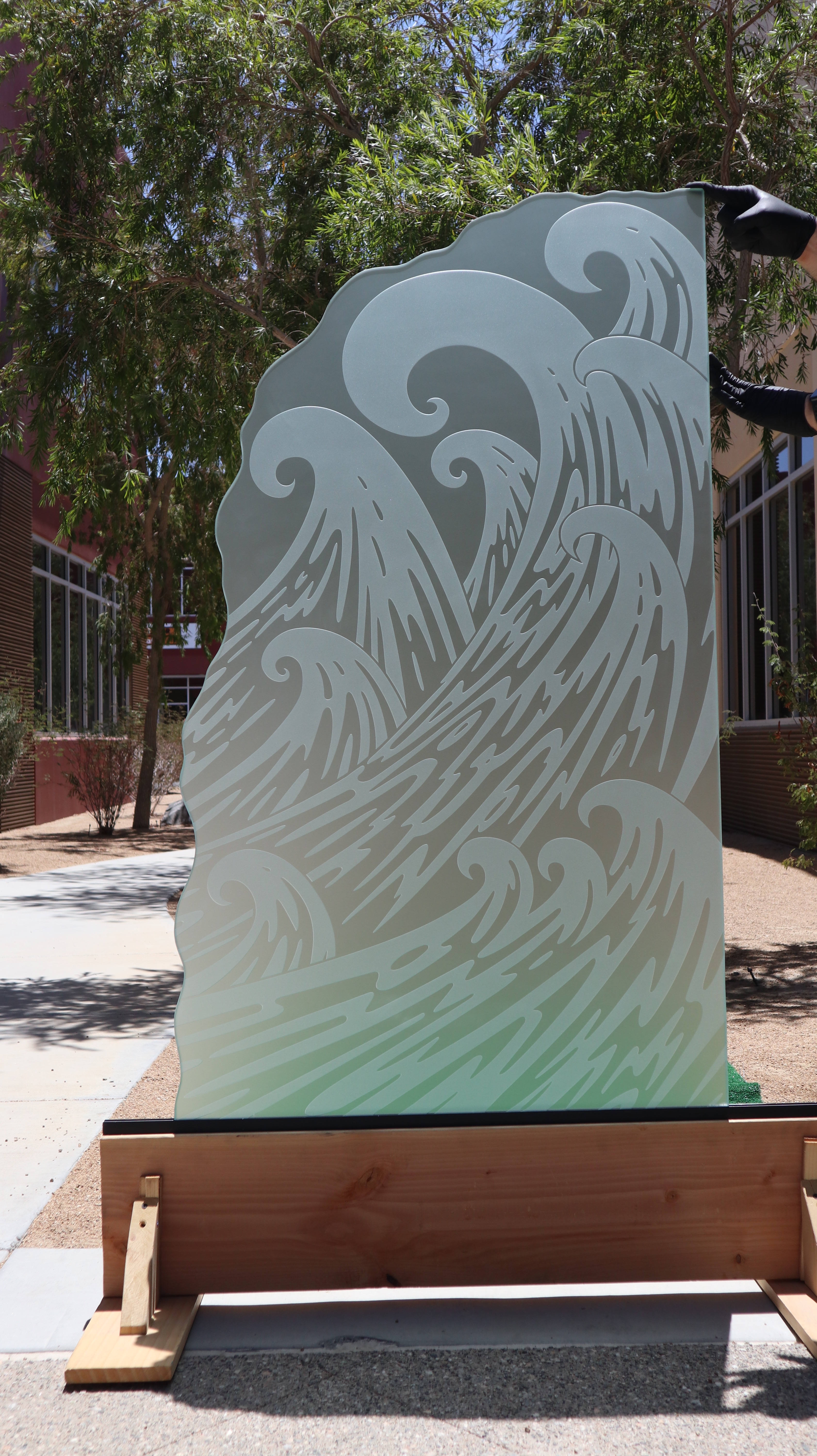 Full outdoor display of a tempered frosted glass shower panel featuring a dynamic 3D wave pattern.