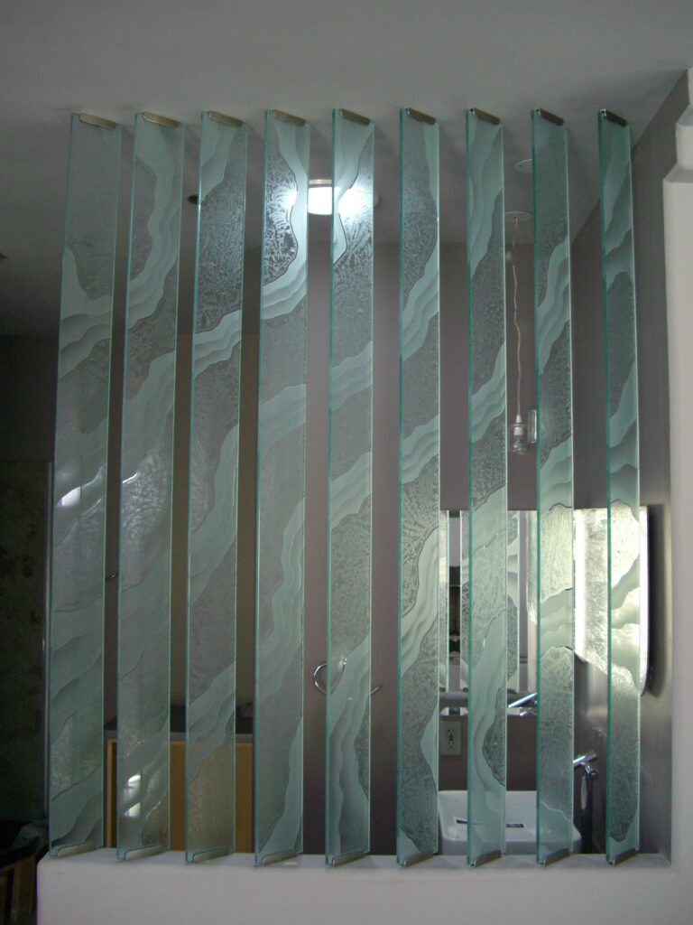 Contemporary glass partition wall composed of vertical decorative glass panels with abstract shoreline-inspired artwork, providing privacy, light, and visual separation.