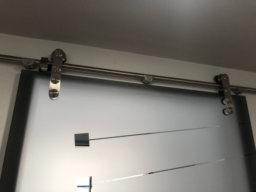 Close-up of decorative glass barn door and hardware