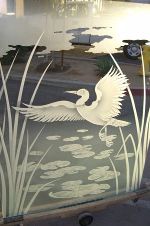 Window showcasing a Frosted Glass Wildlife Design with Sandblast Etched Glass Art by Sans Soucie Dancing Egret Design