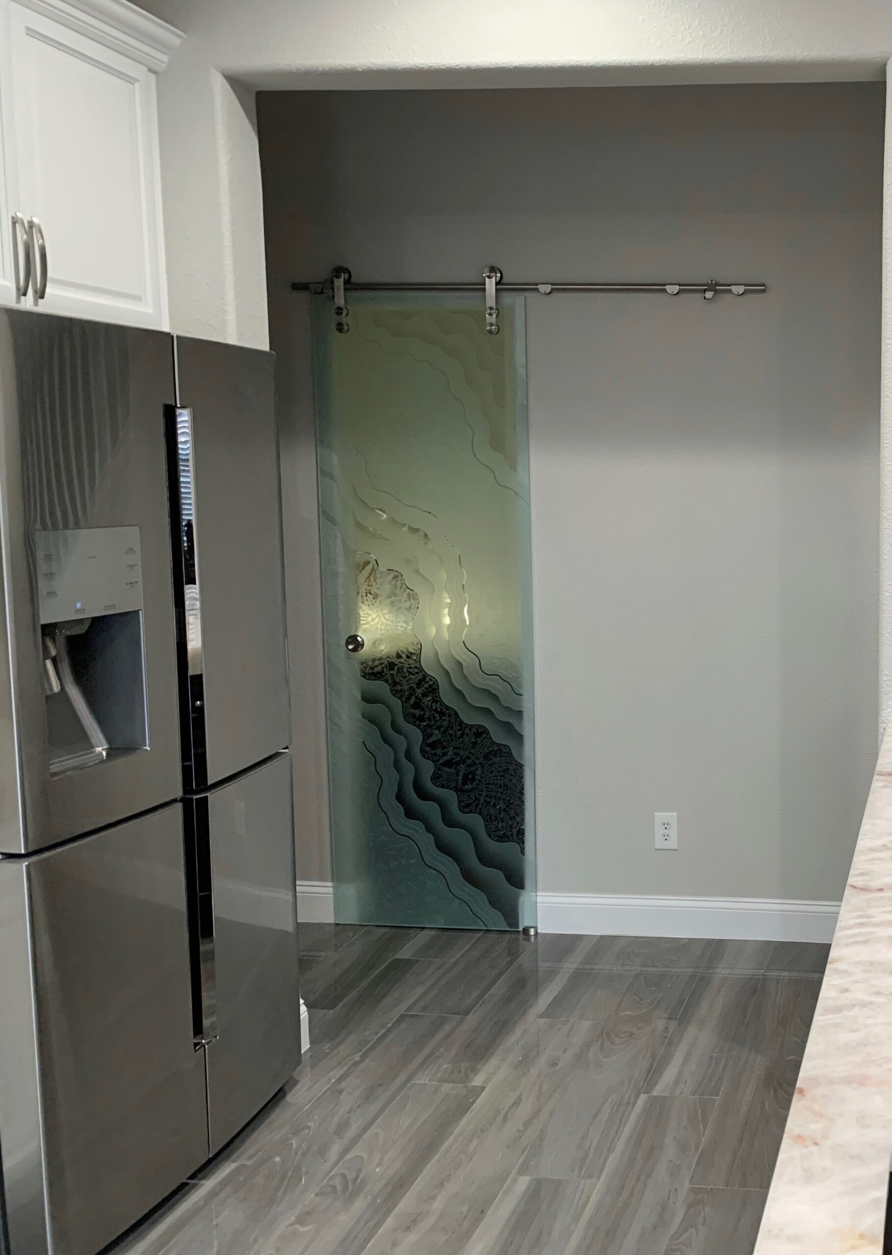 Transitional kitchen featuring a sliding glass door with carved frosted panels and silver hardware