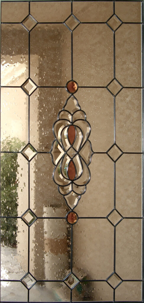 Leaded glass door insert with amber accents, diamond bevels, and decorative beveled glass centerpiece pattern