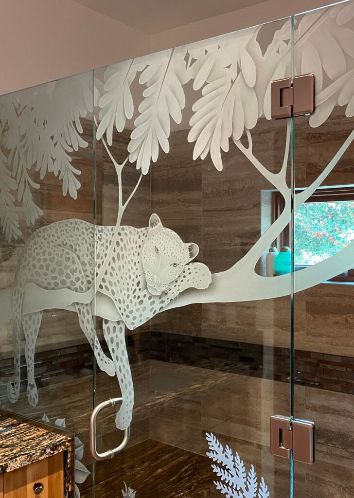 Partially frosted shower door and shower enclosure with etched designs.