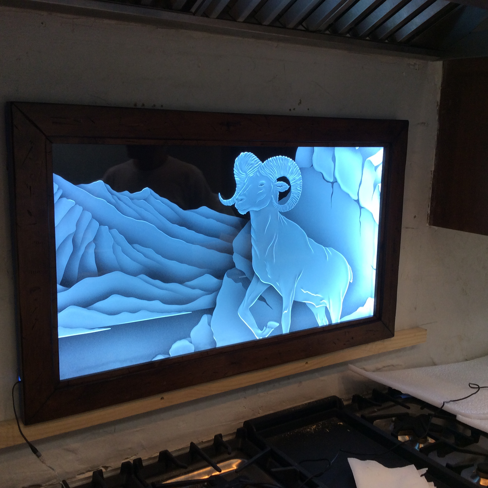 Edge-lit carved glass wall art with sculpted mountain landscape and bighorn sheep design