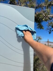 cleaning frosted glass with a soft microfiber hand towel out in the sunshine