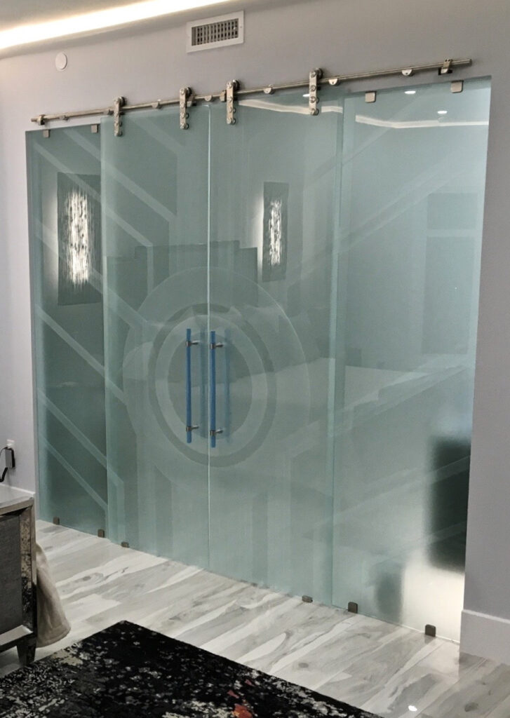 Sliding glass barn doors with frosted geometric design on modern stainless steel track