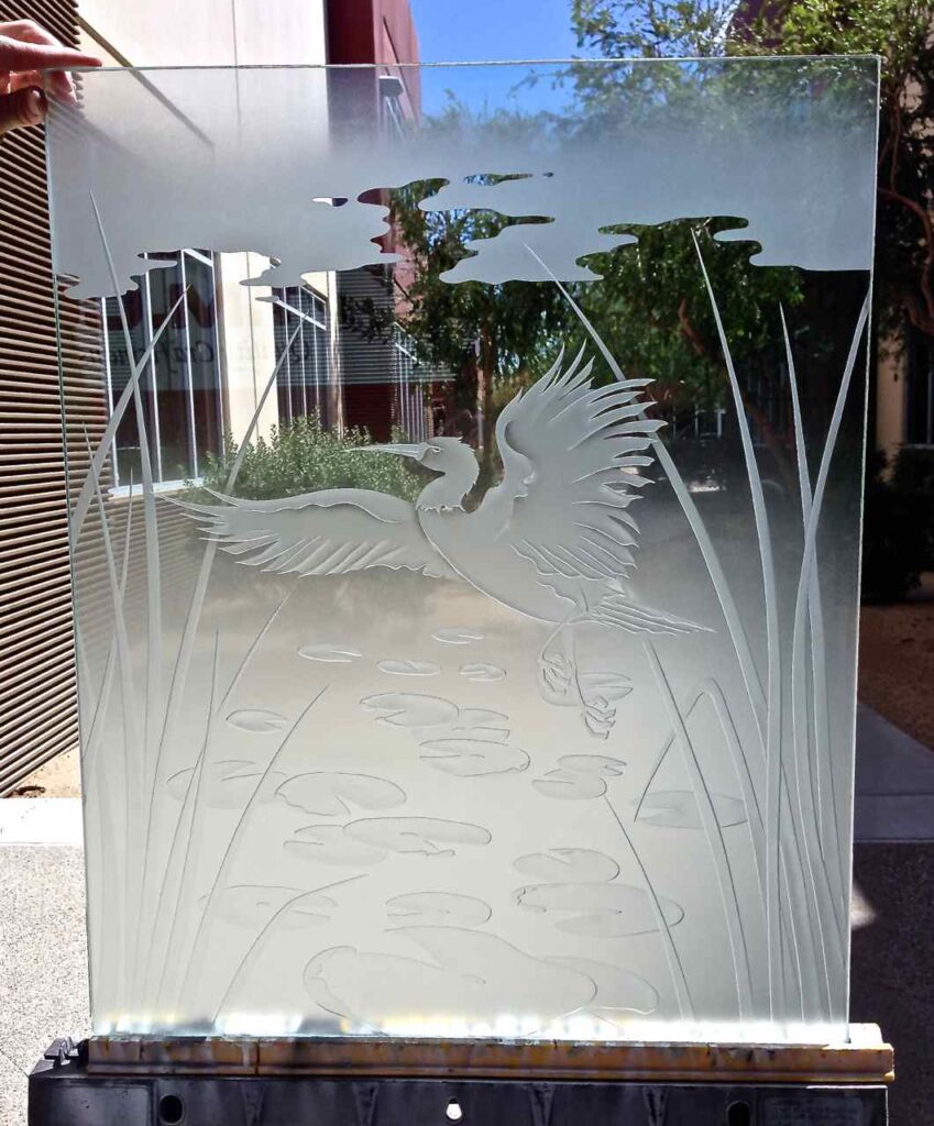 Frosted glass partition panel featuring a dancing egret over a pond with lily pads and cattails, creating a custom wildlife-inspired privacy screen.